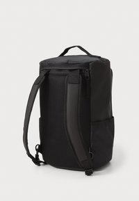 Black backpack with a cylindrical shape, made of durable materials. Features mesh panels, adjustable straps, and a side pocket.