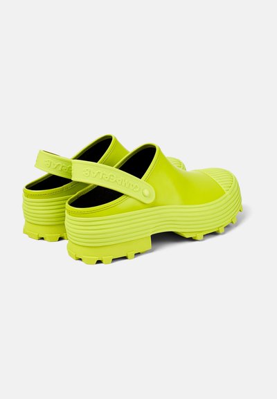 Neon gula slip-on klackar med en texturerad gummisula, justerbar hälen och ruggad detaljering på tån för extra grepp.