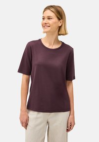 Paarse katoenen t-shirt met korte mouwen, een ronde hals, een ontspannen pasvorm en een gladde textuur. Gecombineerd met lichte, loszittende broeken.