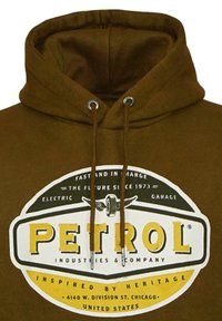 Hnedá mikina s kapucňou s veľkým bielym a žltým logom "PETROL" s čiernymi akcentmi, nastaviteľnými šnúrkami a mäkkou textúrou látky.