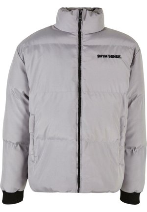 Pilkas pūkinis švarkas su aukštu apykakle, priekiniais užtrauktukais ir juodomis detalėmis. Su išklotais raštais ir šoninėmis kišenėmis. Logotipas ant krūtinės.