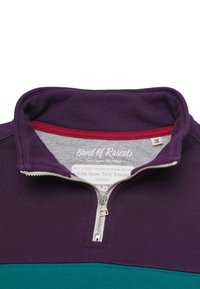 Lila och turkos barnpullover med halv dragkedja och hög krage, visar varumärkesetikett och storlek 110/116 inuti kragen.