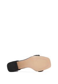 Sandale à talons hauts noire avec une tige en cuir lisse, un bout carré et une semelle en caoutchouc texturée. Elle présente une fine sangle horizontale sur le pied.