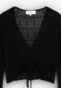 Svart stickad cardigan med V-ringning, detaljerad öppet mönster och justerbar dragsko vid fållen. Tillverkad av ett speciellt garn.