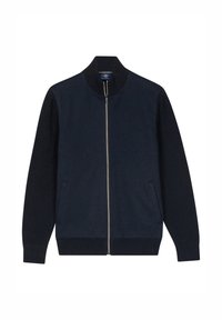 Marineblauwe ritsjack met een gebreide kraag, contrasterende mouwen en zijzakken. Zacht materiaal met een gladde textuur en minimale details.