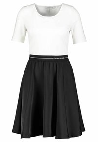 Calvin Klein Jeans-klänning med en vit figurnära överdel med korta ärmar och en svart utsvängd kjol, accentuerad med en kontrasterande midjeband.
