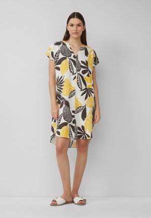 Kurzarmkleid mit weißem Hintergrund und großen gelben und braunen Blattmustern, V-Ausschnitt und lässiger Passform.