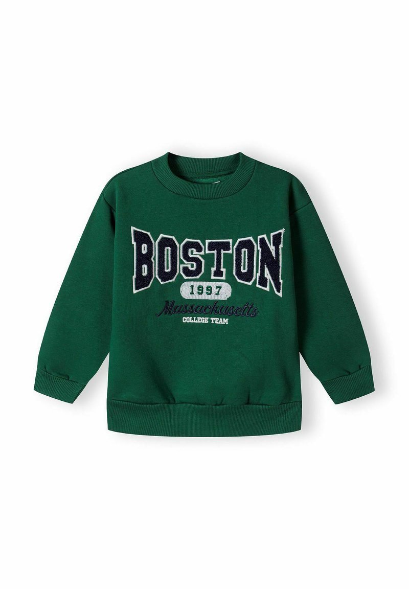 Roheline logošvetser, millel on ribitud varrukaotsad ja alumine äär. Esipinnal on suurte valgete ja tumesiniste tähtedega "BOSTON 1997" ja allpool tekst "Massachusetts College Team".