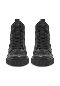 Fekete magas szárú tornacipők vastag bordázott talppal és fekete fűzőkkel, elölnézetből, fehér háttér előtt.