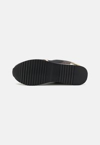 Zwarte sneakerzool met een gestructureerd, geribbeld ontwerp. Heeft een lichte kromming, met gladde accenten en een platte hak voor stabiliteit.