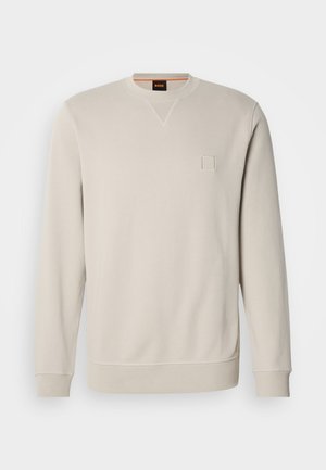 Sweatshirt bege claro com decote redondo e mangas compridas. Apresenta um pequeno emblema com o logótipo em relevo no peito e punhos canelados.