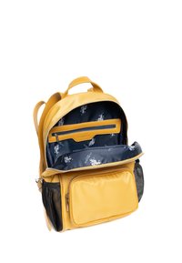 Žlutý kožený batoh s hlavní kapsou na zip, která uvnitř má modrý vzorovaný podšívku, a přední kapsou na zip. Černé síťované boční kapsy.