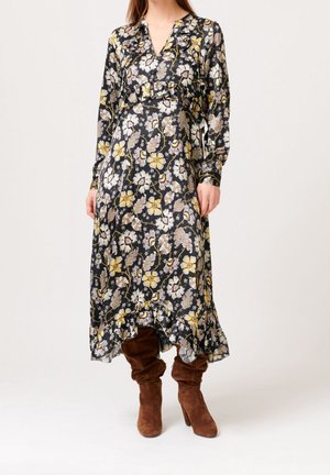 Zwarte bloemenjurk met lange mouwen, gerimpelde halslijn, gele en paarse bloemen en een gelaagde zoom. Draag het met bruine suède knielaarzen.