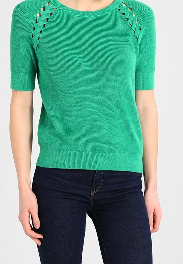 Grøn kortærmet strikket sweater med udskæringer på skuldrene, ribbet tekstur og tætsiddende nederkant. Sammen med mørke denim jeans.