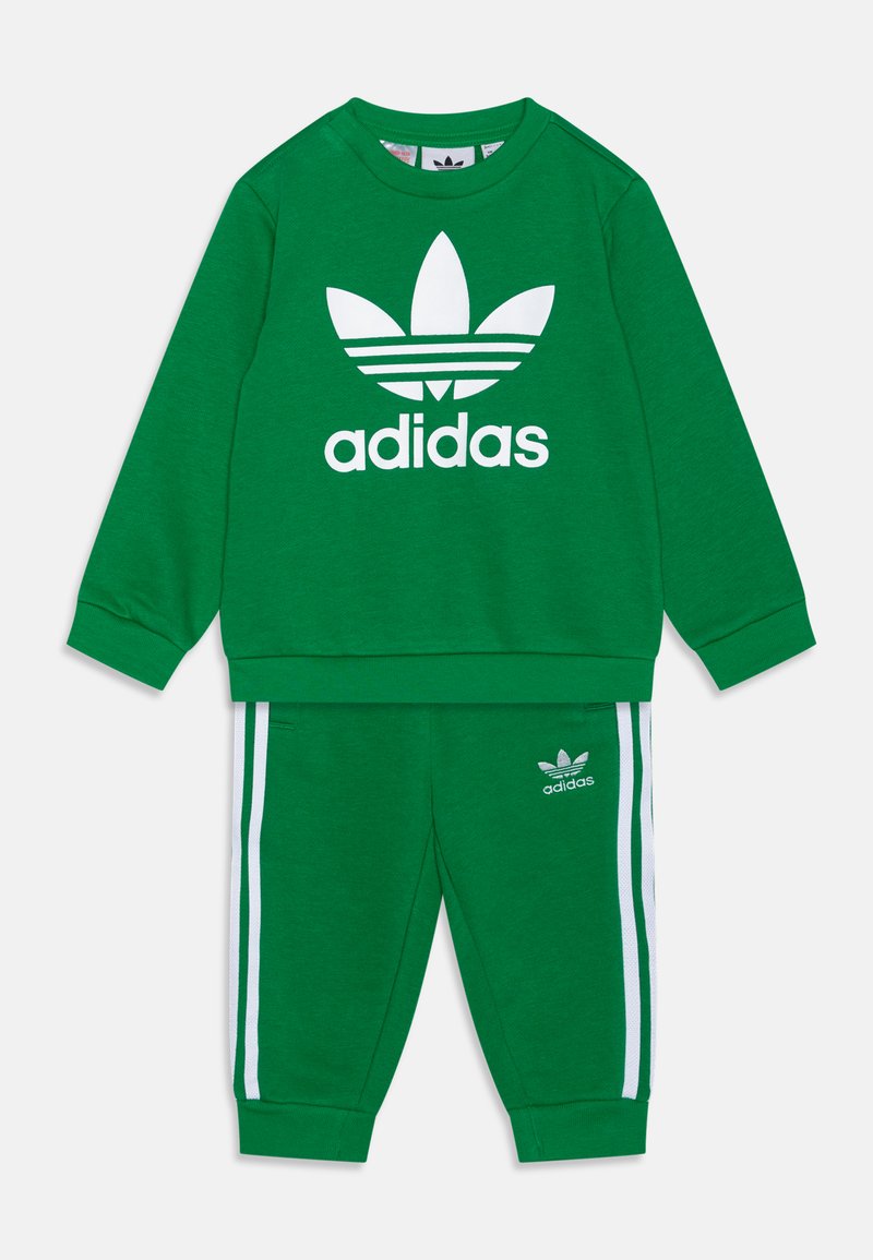 Sweatshirt verde e calças de treino a condizer, feitas de um tecido suave, apresentando um grande logótipo branco da Adidas e riscas brancas ao longo dos lados das calças.