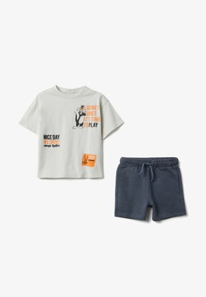 T-shirt blanc à manches courtes avec Sylvester et le texte "Looney Tunes C'est l'heure de jouer", associé à un short à cordon bleu marine.