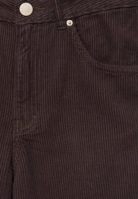 Bruine corduroy broek met fijne ribbels, een ritssluiting, en een voorzak, met een metalen knoopsluiting en contrasterende stiksels.