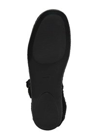 Talpa de cauciuc negru a unei încălțări plate, cu zone texturate pentru aderență în zona călcâiului și a vârfului, și un mic logo al brandului aproape de arcada piciorului.