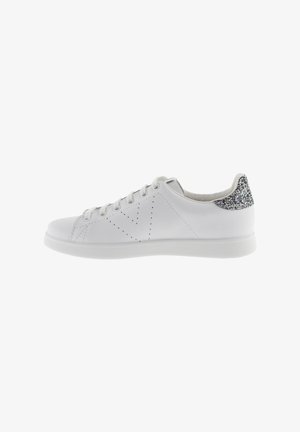 White lace-up sneaker with perforated side design and glittery silver heel tab, shown in profile on a white background.