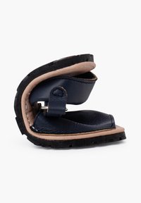 Sandalo in pelle blu navy con suola in gomma. Presenta un design piegato, chiusura con cinturino e superficie liscia. Costruzione leggera.