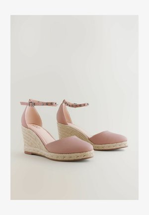 Roosa vankri sandaalid, millel on tekstureeritud materjal, pahkluulöödav rihm, millel on hõbedased nurgad ja punutud jute vankri kontsad. Sujuv ümar varvaste disain.