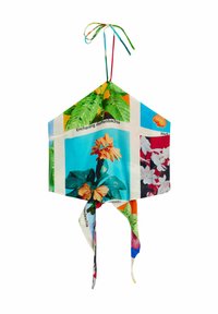 Lanterna in tessuto colorato con motivi floreali, forma esagonale, con un nastro annodato in cima e dettagli stampati decorativi attorno.