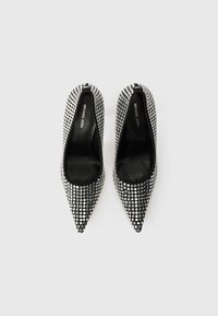 Black high-heeled shoes with pointed toes, covered in silver studs. Interior is black leather with "Michael Kors" branding on the insole.