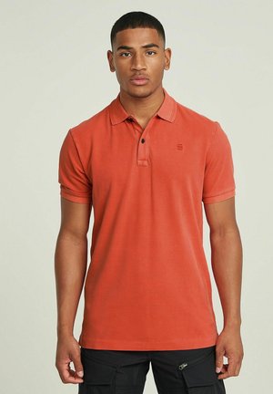 Polo shirt rosso a maniche corte in cotone con colletto e patta a tre bottoni; presenta un piccolo logo sul petto e polsini a costina.