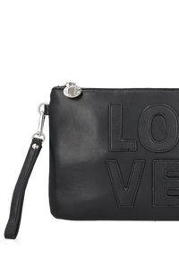 Pochette in pelle nera con testo "LOVE" in rilievo, chiusura con zip, ferramenta argento e cinturino da polso staccabile. Texture liscia, design minimalista.
