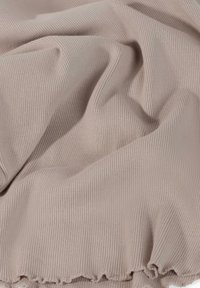 Geribbeld stof in een zachte beige kleur met een gladde textuur en een golvende, geschulpte rand. Het materiaal is lichtgewicht en flexibel.