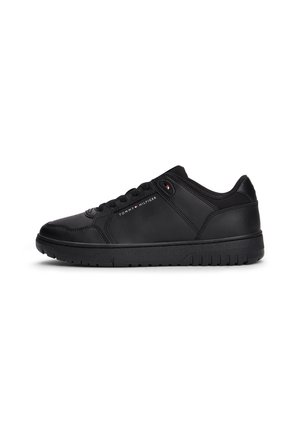 Sort lavtop sneaker med snørebånd, struktureret sål og lille Tommy Hilfiger-logo på siden og nær snørebåndene.