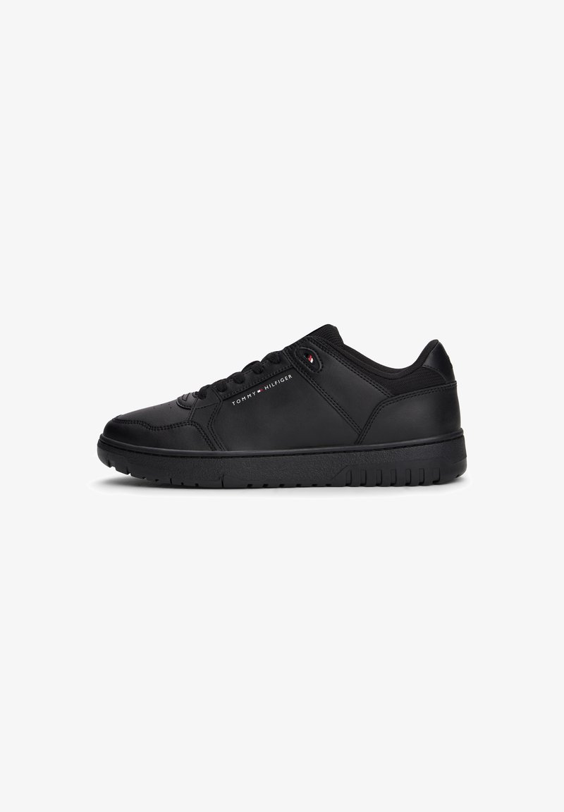 Baskets basses noires avec lacets, semelle texturée et petit logo Tommy Hilfiger sur le côté et près des lacets.