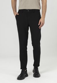 Zwarte op maat gemaakte broeken met een slim fit, met een platte voorkant, knoopsluiting en zakken. Gemaakt van een gladde, lichte stof.