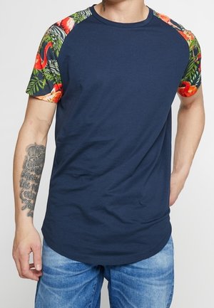 Navy T-shirt with short sleeves featuring colorful tropical print on shoulders, round neckline, and a curved hem, made from cotton blend fabric.