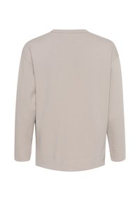 Lys beige langærmet skjorte med rund halsudskæring, blød tekstur og en let løs pasform. Har enkle stikninger som detaljer.