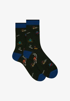 Knit socks in dark green featuring colorful skiing figures, blue cuffs, and contrasting toe accents. Pattern includes ski trails and skiers.