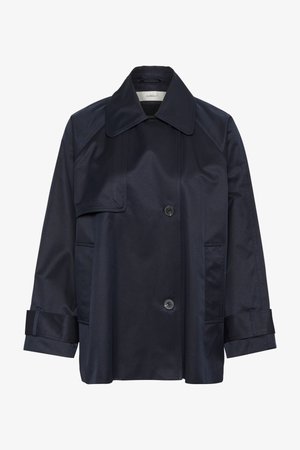 Tumši zilas krāsas, vidēja garuma mēteli, kas izgatavots no gludas, ūdensizturīgas auduma. Tam ir liels apkaklis, divi pogu rindas un divas sānu kabatas.