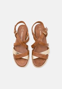 Sandali in pelle marrone con cinturini incrociati, dettagli dorati e fibbia regolabile. Soletta texturizzata con il nome del brand impressa. Taglia 37.