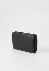 Portafoglio in pelle nera con superficie texturizzata e design pieghevole, dotato di chiusura con zip e foderatura interna liscia.