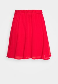 Jupe rouge longueur genou avec taille élastique et tissu léger et fluide flottant librement sur un fond uni.