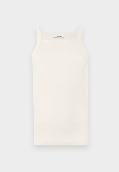 Crème geribbelde tanktop met dunne bandjes, aansluitend ontwerp en rechte zoom. Label leest "IVY OAK." Het materiaal lijkt zacht en rekbaar te zijn.