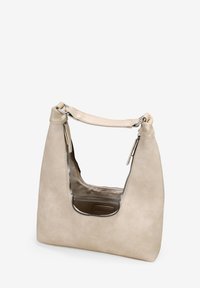 Bolso de mano de cuero beige con forma curva, que cuenta con una gran abertura recortada y detalles en cremallera plateados. Textura suave y correa ajustable.