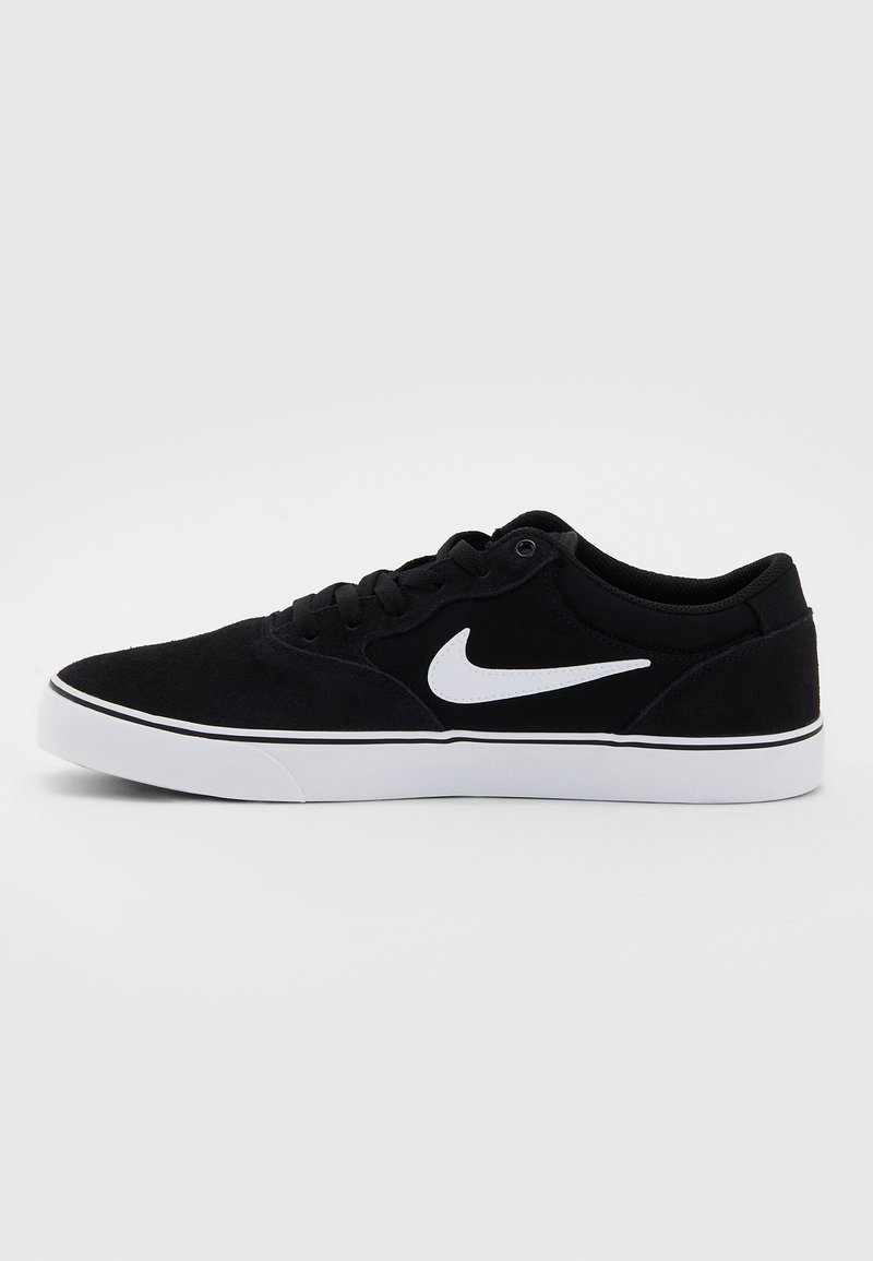 Czarne zamszowe trampki do skateboardu z białym logo swoosh Nike, kontrastową białą podeszwą i czarnymi sznurowadłami. Niska sylwetka z gładką teksturą.