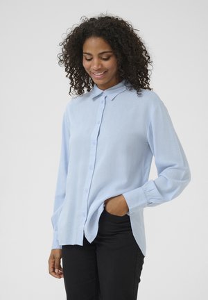 Light blue button-up shirt with a collared neckline, long sleeves with gathered cuffs, and a relaxed fit. Slight texture visible on fabric.
