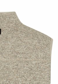 Beige Strickpulloverweste aus strukturiertem Stoff, mit hohem Kragen und einer horizontalen Naht über den Rücken, ausgestattet mit einem kleinen schwarzen Etikett.