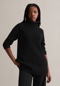 Schwarzer Strickpullover mit hohem, umgeschlagenem Kragen. Verfügt über eine strukturierte Oberfläche, lange Ärmel mit umgeschlagenen Bündchen und eine lockere Passform.