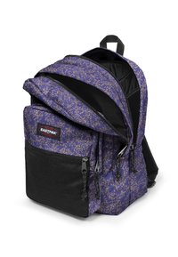 Zaino viola con design a macchie, tasca anteriore in rete nera, doppia cerniera, spallacci imbottiti e regolabili, e anelli laterali per ulteriori opzioni di trasporto.