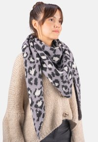 Écharpe en imprimé léopard gris et noir en tissu doux, drapée élégamment. Pull en tricot texturé en dessous avec des accents côtelés et des détails de boutons.