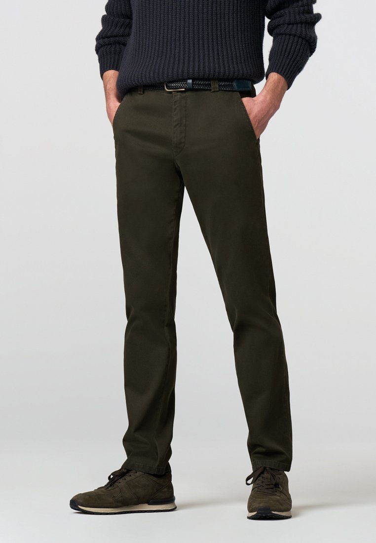 Olijf groene chinos met een slim fit, gemaakt van lichtgewicht katoen, met zijzakken en een gladde textuur, gecombineerd met donkere schoenen.