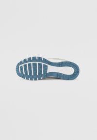 Nike sneaker talpája, amelyet textúrált kék gumival díszítenek, téglalap alakú és kör alakú mintázatokkal, fehér kiemelésekkel és sima középső résszel.